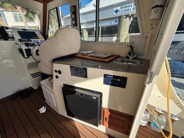 Slide: The Image of Interior of 2018 Eastern 27 Islander Hardback with helm and kitchenette. - 3