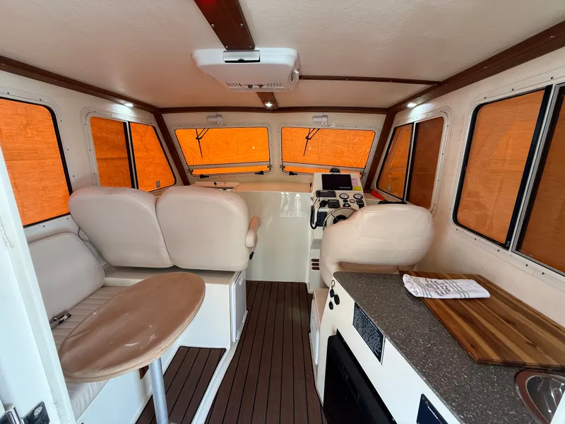 Slide: The Image of Interior of a 2018 Eastern 27 Islander Hardback boat with seating and helm. - 32