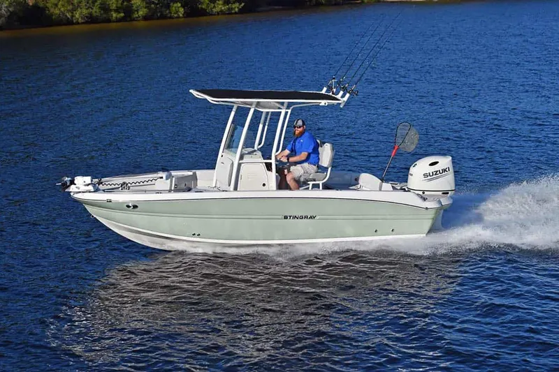 Slide: The Image of Manufacturer Provided Image: 2025 Stingray 216 CC boat cruising on a lake with a Suzuki outboard motor. - 11