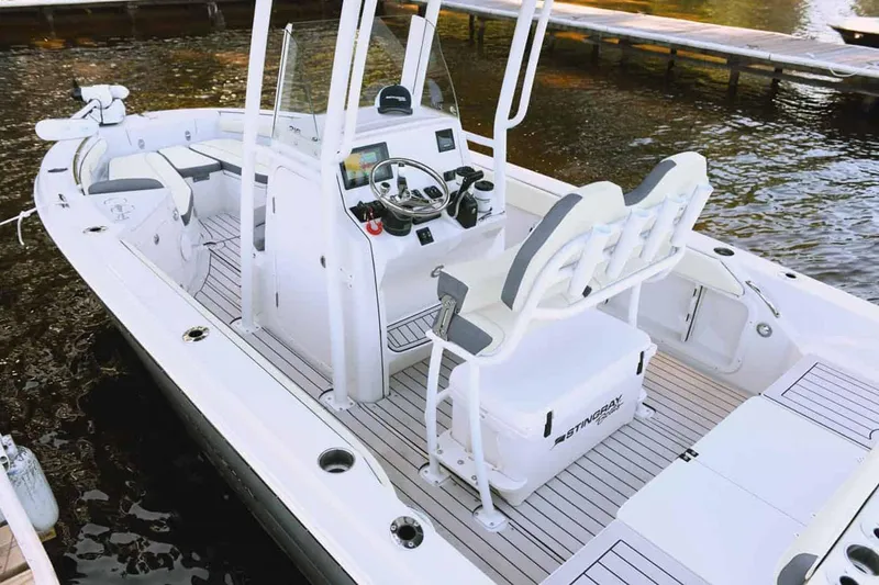 Slide: The Image of Manufacturer Provided Image: 2025 Stingray 216 CC boat with sleek design and modern features docked on water. - 13