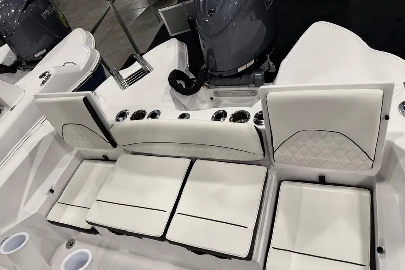 Slide: The Image of 2026 Stingray 216 CC boat interior with white cushioned seating and cup holders. - 2