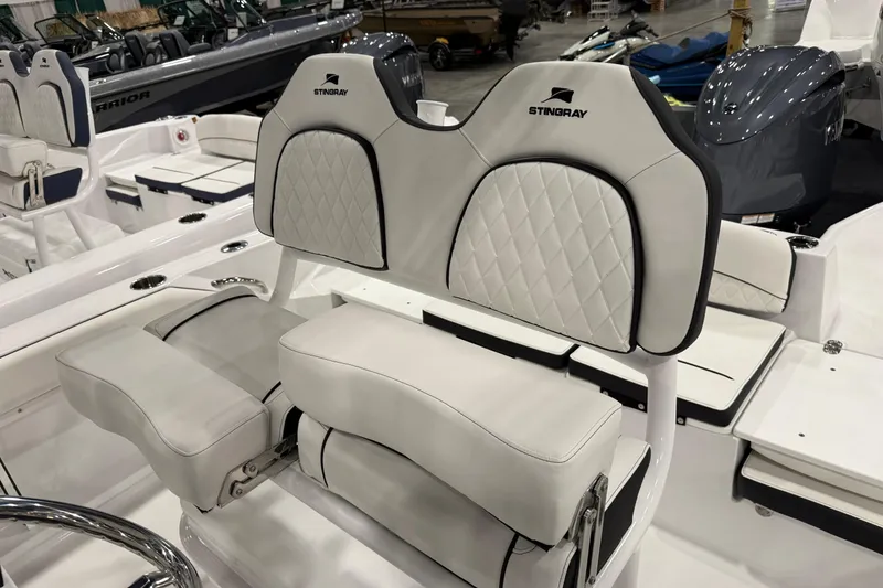 Slide: The Image of 2026 Stingray 216 CC boat interior with white cushioned seating and elegant design. - 5