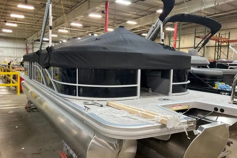 Slide: The Image of 2026 Bennington 24SXSR pontoon boat in a warehouse, covered and ready for transport. - 10
