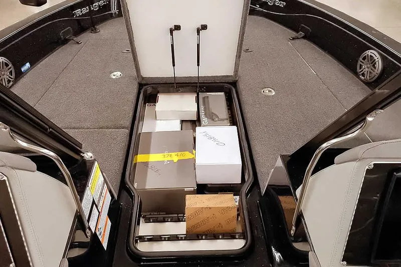Slide: The Image of 2026 Ranger 620xFS Pro boat storage compartment with boxes and equipment. - 14