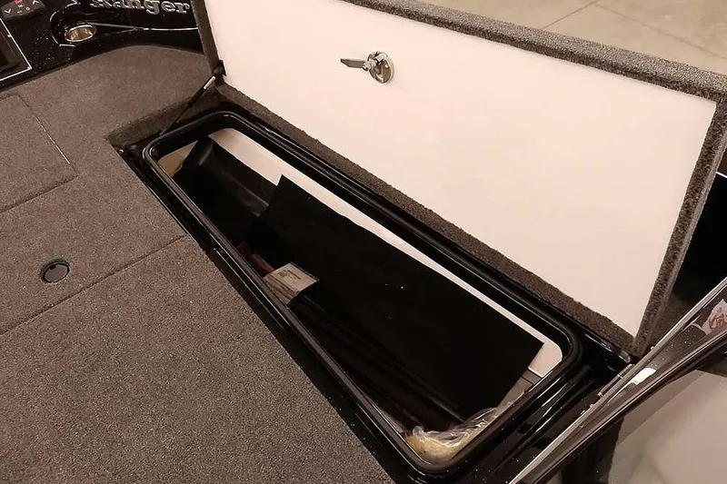 Slide: The Image of Open storage compartment in 2026 Ranger 620xFS Pro boat, featuring carpeted interior. - 15