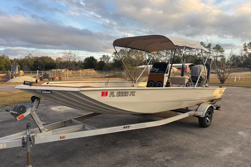 Slide: The Image of 2015 Express XP20CC boat on trailer with canopy, parked outdoors under cloudy sky. - 14
