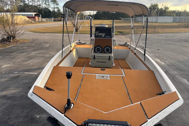 Slide: The Image of 2015 Express XP20CC boat with canopy, parked on pavement, featuring tan deck and console. - 17