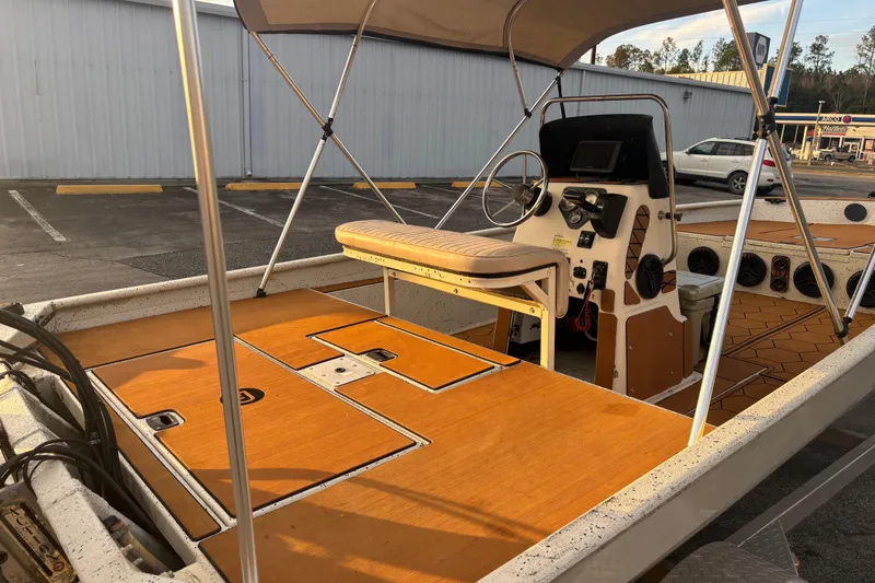 Slide: The Image of 2015 Express XP20CC boat interior with steering console and seating, parked outdoors. - 19