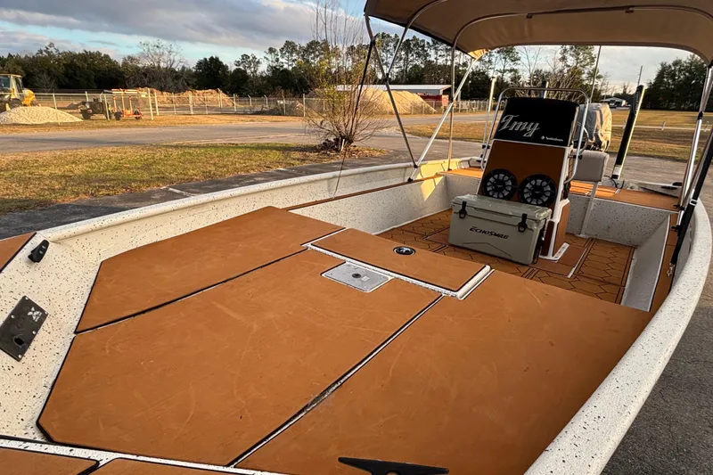 Slide: The Image of 2015 Express XP20CC boat with tan deck, canopy, and cooler on a sunny day. - 22