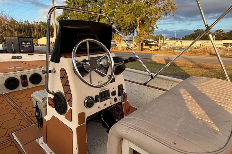 Slide: The Image of 2015 Express XP20CC boat interior with steering wheel and control panel, parked outdoors. - 23