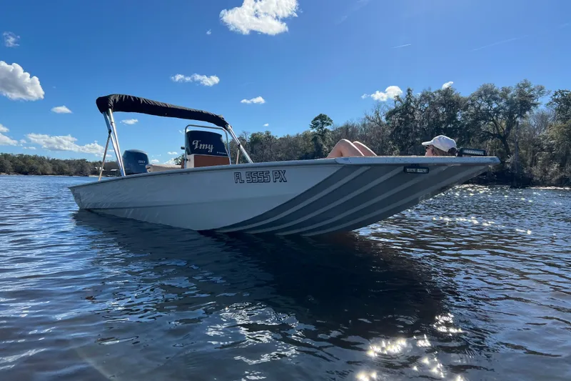 Slide: The Image of 2015 Express XP20CC boat on a sunny lake with a person relaxing onboard. - 6