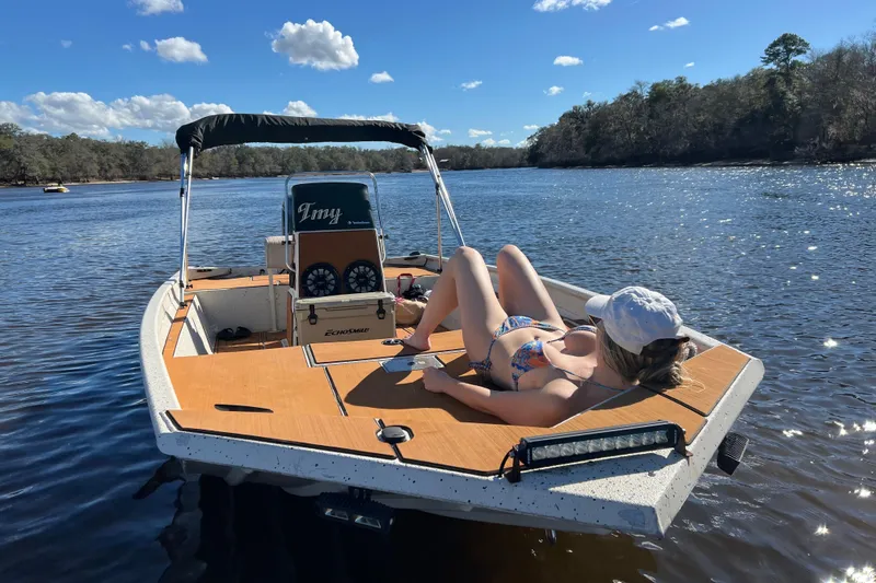 Slide: The Image of Woman sunbathing on 2015 Express XP20CC boat in scenic river setting. - 7