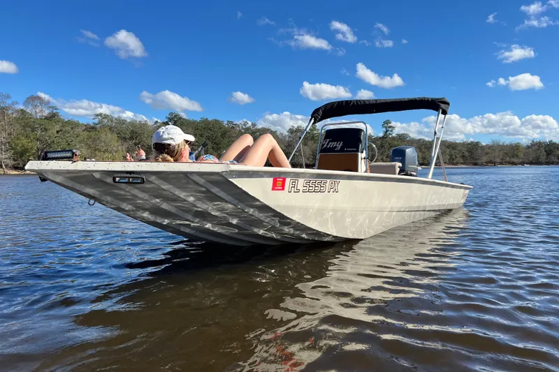 Slide: The Image of 2015 Express XP20CC boat on calm water, person relaxing under clear blue sky. - 8