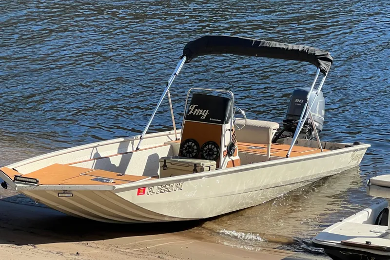 Slide: The Image of 2015 Express XP20CC boat with canopy, docked on sandy shore. - 9