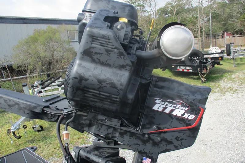 Slide: The Image of 2026 Gator Tail 1854 Extreme outboard motor in a yard setting. - 8