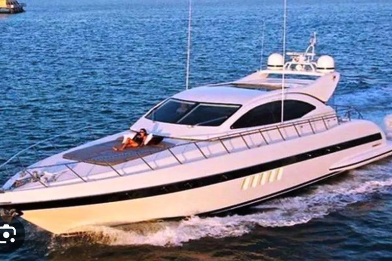 The Image of Luxurious 2004 Mangusta 72 yacht cruising on open water with a person relaxing on deck. - 0