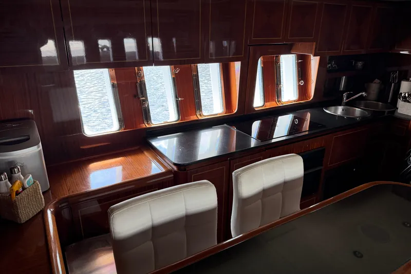 Slide: The Image of Luxurious 2004 Mangusta 72 yacht interior with elegant wood cabinetry and modern kitchen amenities. - 25