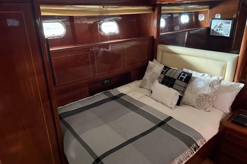 Slide: The Image of Luxurious cabin interior of 2004 Mangusta 72 yacht with elegant bedding and wood paneling. - 28