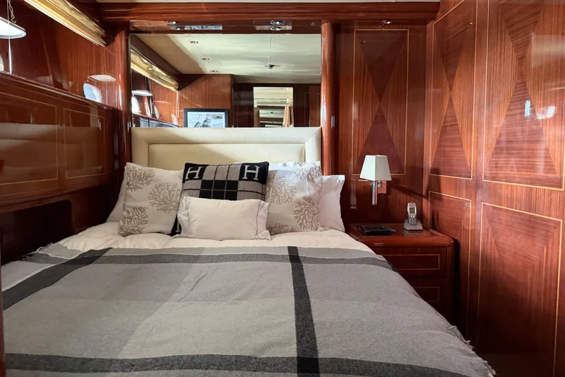 Slide: The Image of Luxurious 2004 Mangusta 72 yacht bedroom with elegant wood paneling and plush bedding. - 30
