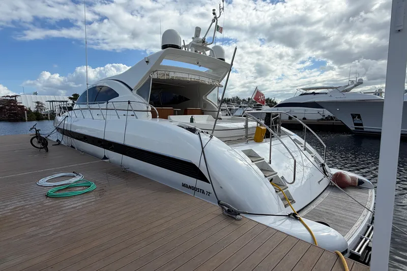 Slide: The Image of Luxury 2004 Mangusta 72 yacht docked at marina under cloudy sky. - 38