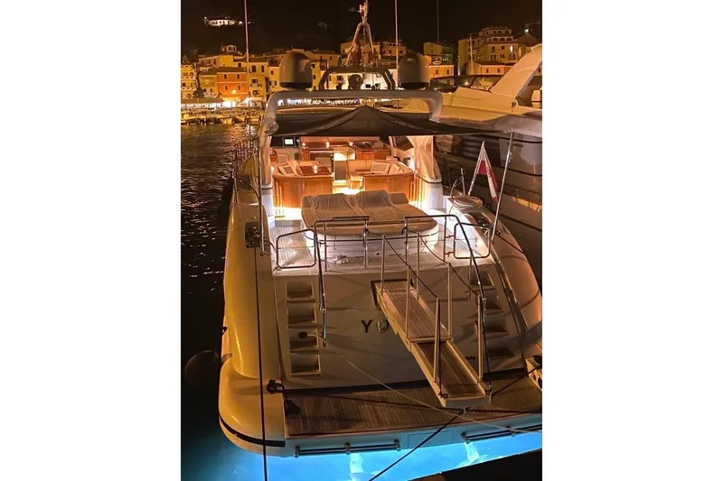 Slide: The Image of Luxurious 2004 Mangusta 72 yacht docked at night, illuminated with warm lights. - 39