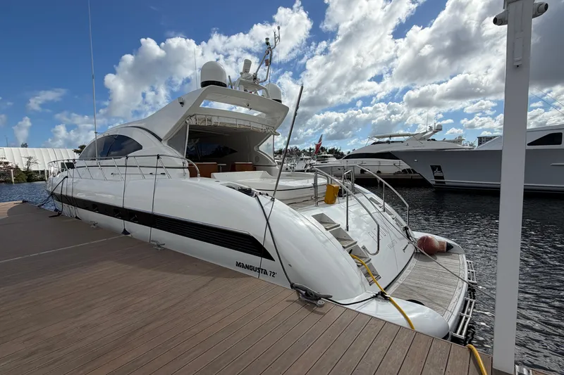 Slide: The Image of 2004 Mangusta 72 yacht docked under a partly cloudy sky. - 4
