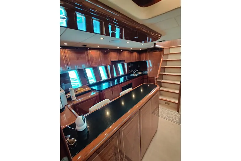 Slide: The Image of Luxurious 2004 Mangusta 72 yacht interior with elegant wood cabinetry and modern kitchen amenities. - 51