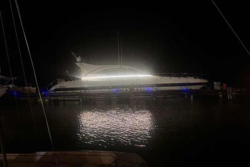 Slide: The Image of Illuminated 2004 Mangusta 72 yacht docked at night, reflecting on calm water. - 61