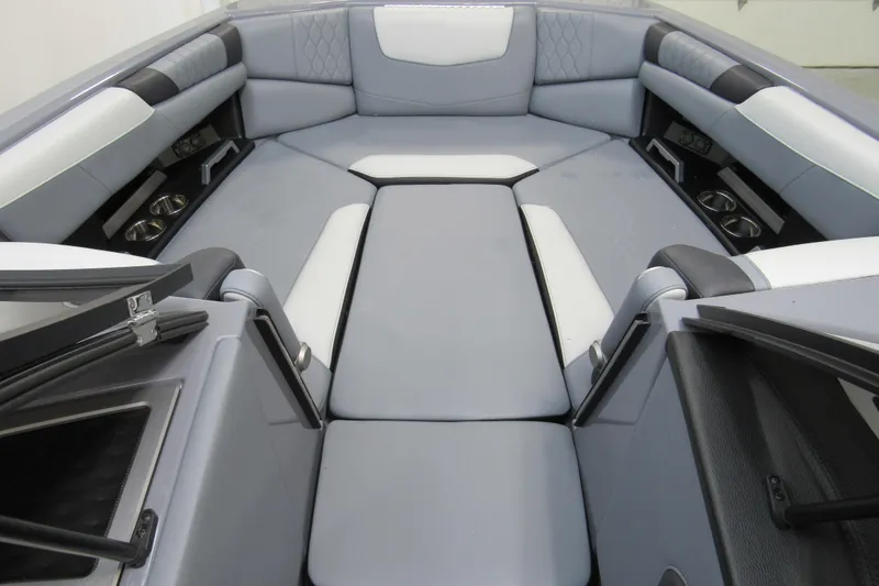 Slide: The Image of 2024 Malibu M220 boat interior with luxurious seating and cup holders. - 10