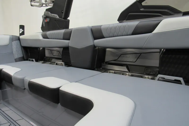 Slide: The Image of 2024 Malibu M220 boat interior with sleek, modern seating and cup holders. - 12
