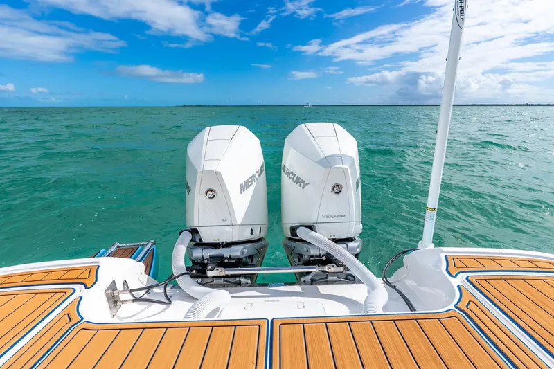 Slide: The Image of 2024 Caymas 281 HB boat with dual Mercury engines on turquoise water. - 15