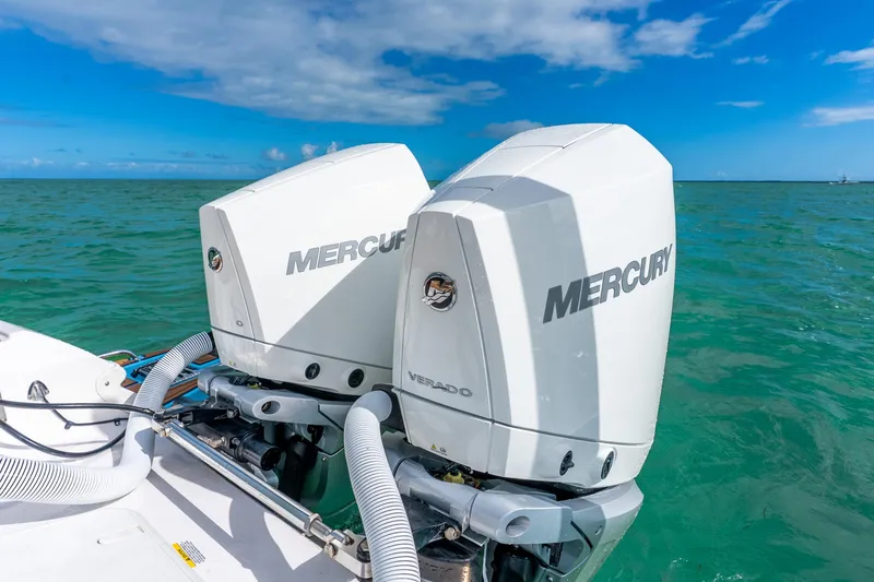 Slide: The Image of 2024 Caymas 281 HB boat with dual Mercury outboard engines on turquoise water. - 16