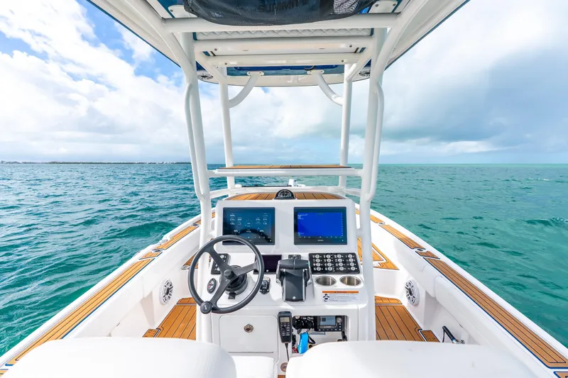 Slide: The Image of 2024 Caymas 281 HB boat dashboard with ocean view, featuring modern controls and navigation screens. - 20