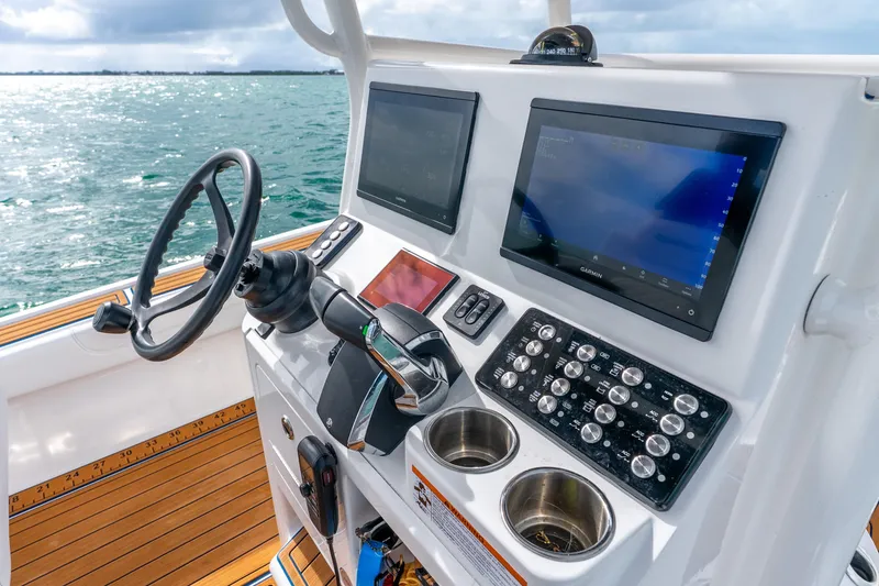 Slide: The Image of 2024 Caymas 281 HB boat dashboard with steering wheel and navigation screens. - 21