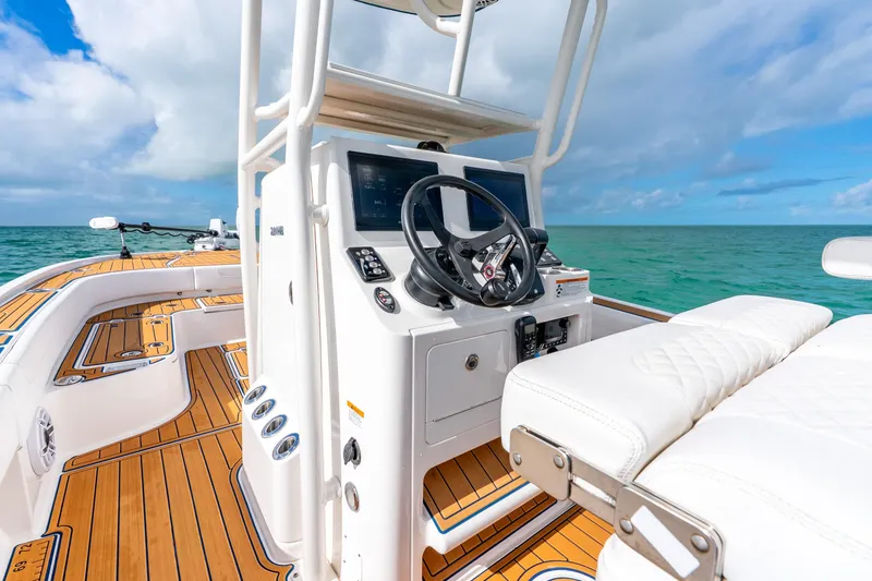 Slide: The Image of 2024 Caymas 281 HB boat interior with helm, ocean view, and teak flooring. - 22