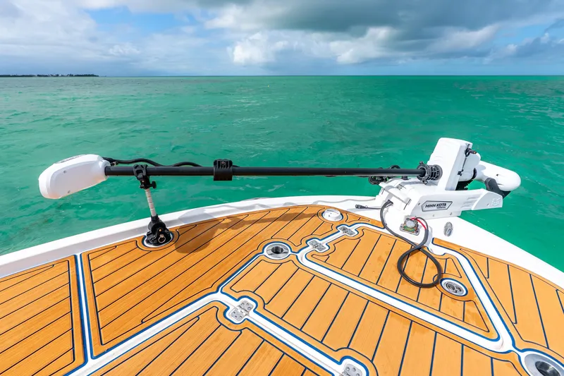 Slide: The Image of 2024 Caymas 281 HB boat deck with Minn Kota trolling motor on turquoise water. - 7