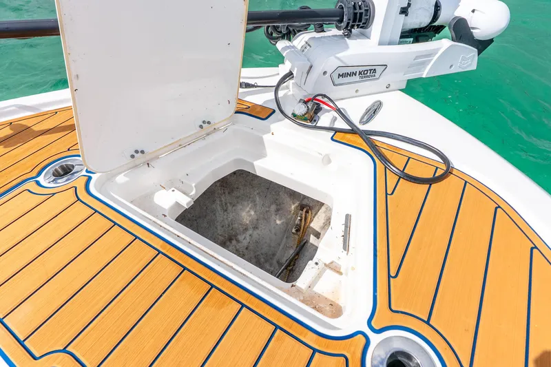 Slide: The Image of 2024 Caymas 281 HB boat deck with open storage compartment and Minn Kota trolling motor. - 8