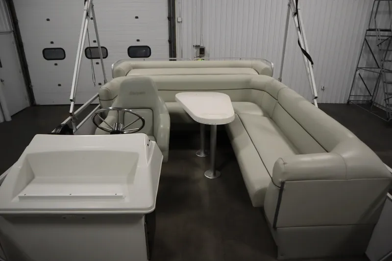 Slide: The Image of Interior of a 1994 San Pan 2500 pontoon boat with beige seating and steering wheel. - 12