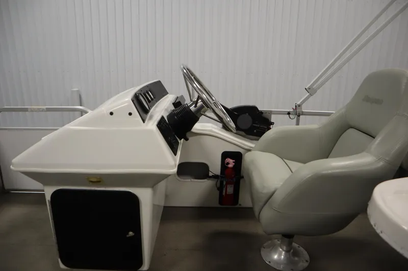 Slide: The Image of 1994 San Pan 2500 boat helm with steering wheel and captain's chair. - 13