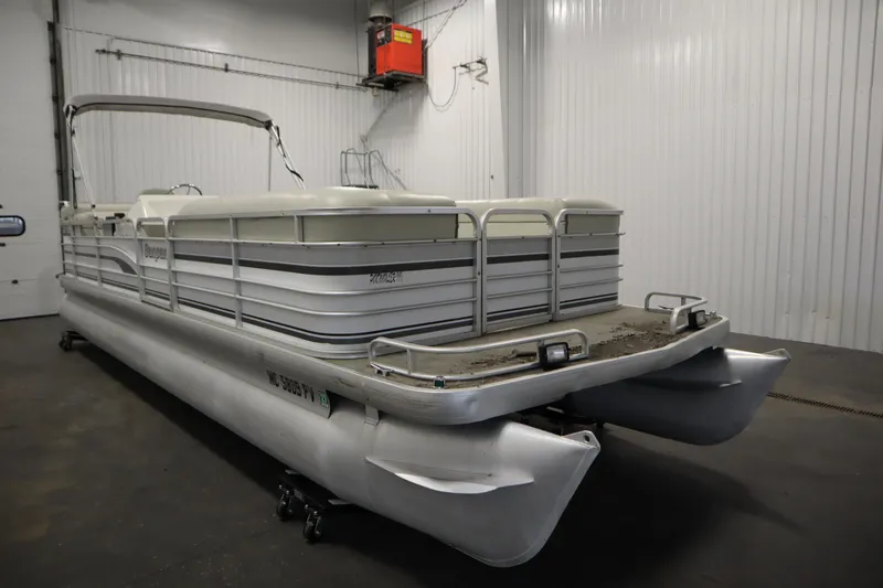 Slide: The Image of 1994 San Pan 2500 pontoon boat in a storage facility. - 2