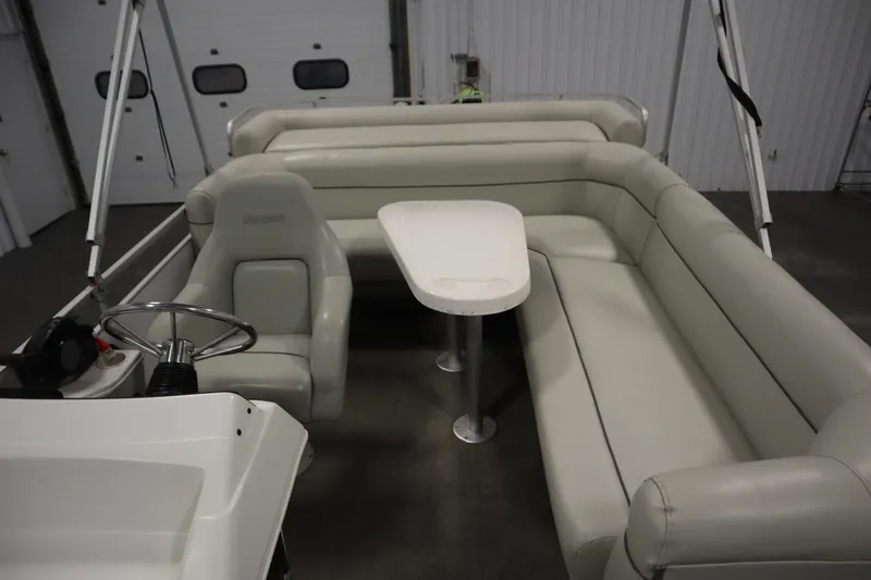 Slide: The Image of Interior of a 1994 San Pan 2500 boat with white seating and table. - 23