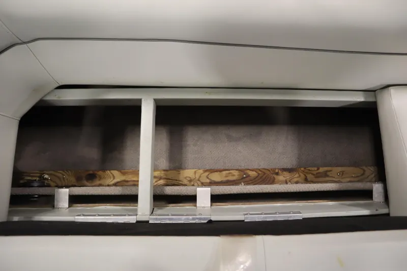 Slide: The Image of Interior storage compartment of a 1994 San Pan 2500 boat, featuring wood and metal construction. - 25