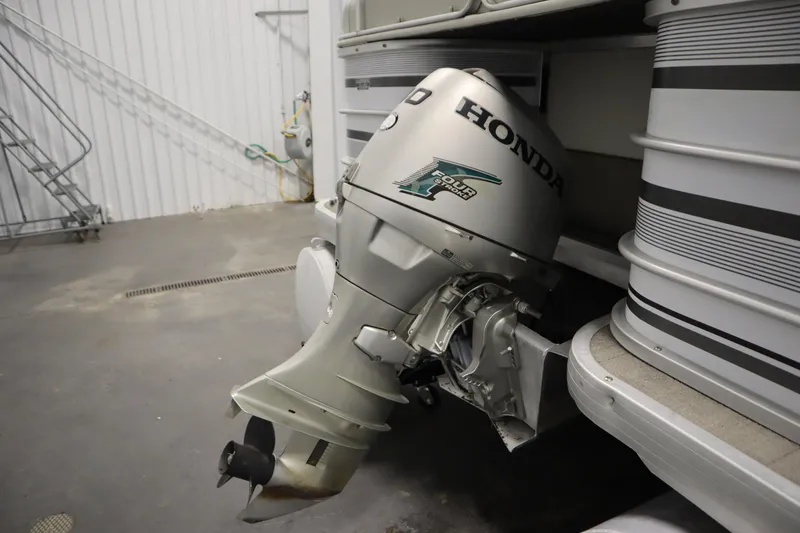 Slide: The Image of Outboard motor on a 1994 San Pan 2500 pontoon boat in a storage facility. - 29