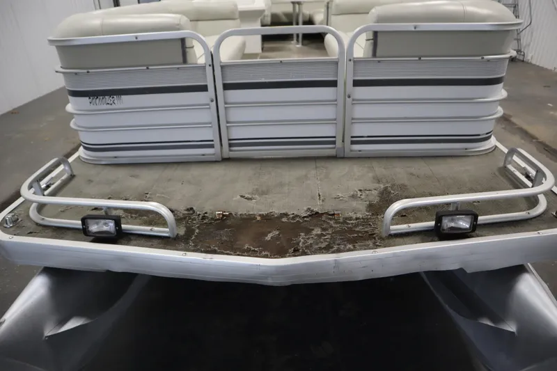 Slide: The Image of 1994 San Pan 2500 pontoon boat with worn deck and metal railings. - 34
