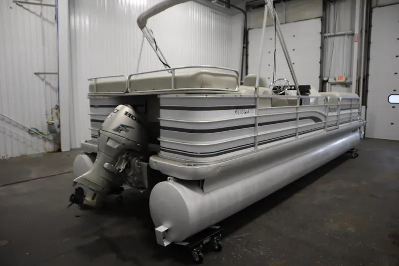 Slide: The Image of 1994 San Pan 2500 pontoon boat with Honda outboard motor in a garage setting. - 4