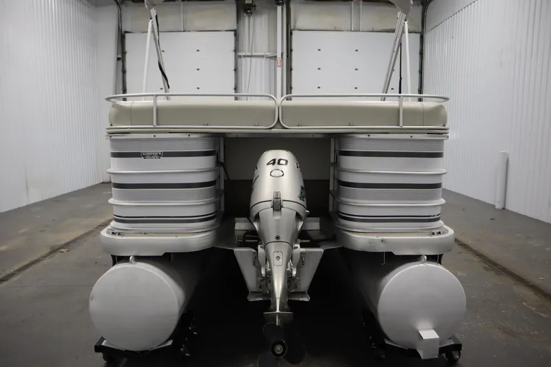 Slide: The Image of 1994 San Pan 2500 pontoon boat with outboard motor in a garage setting. - 5