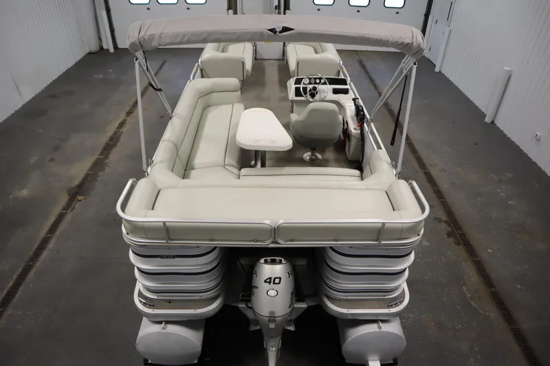 Slide: The Image of San Pan 2500 pontoon boat, 1994 model, with seating and canopy in a garage setting. - 9