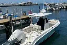Slide: The Image of 2019 Boston Whaler 230 Outrage docked at marina with American flag. - 3