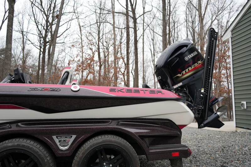 Slide: The Image of 2021 Skeeter FXR21 Apex boat with Yamaha engine in wooded area. - 5