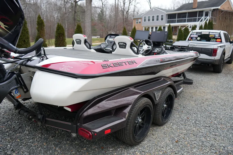 Slide: The Image of 2021 Skeeter FXR21 Apex boat on trailer, parked outdoors near a house. - 7